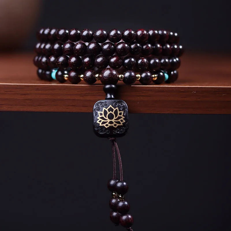 Zambia rosewood Buddha beads bracelet with 0.6 cm beads and flat lotus pendant on wooden surface