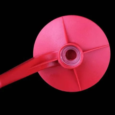 Red plastic Magic Tap soda dispenser attached to 2-liter bottle showing push-in tap mechanism
