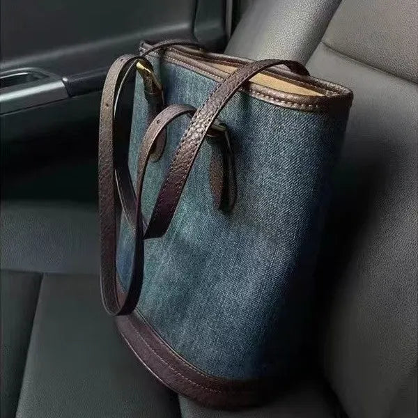 Denim wash patchwork one-shoulder bucket handbag showing front view and strap.