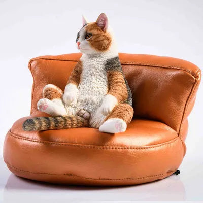 Small resin cat figurine on a sofa, a 1:6 scale car dashboard ornament.