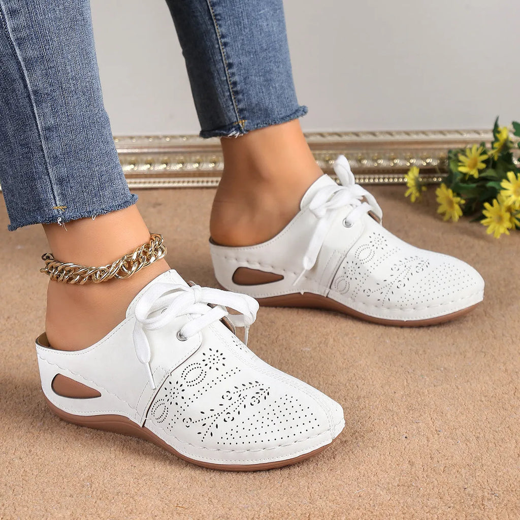 Women's black suede lace-up wedge slippers with hollow-out design and rubber sole.