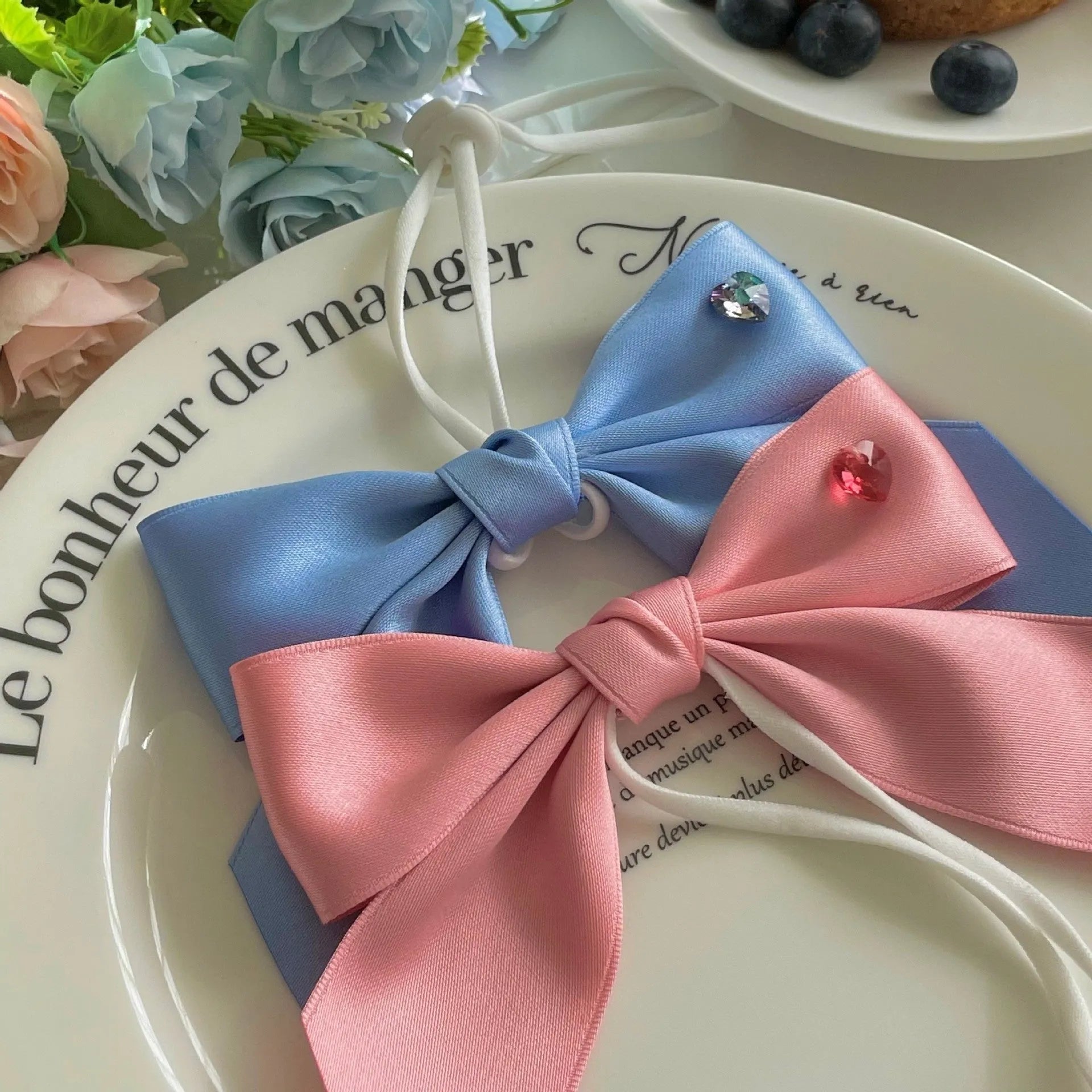 Blue princess style dog hair band with adjustable bow on a dog's head.