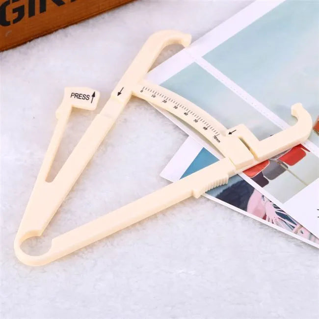 Clear acrylic body fat caliper skin fold thickness measuring instrument on a white background