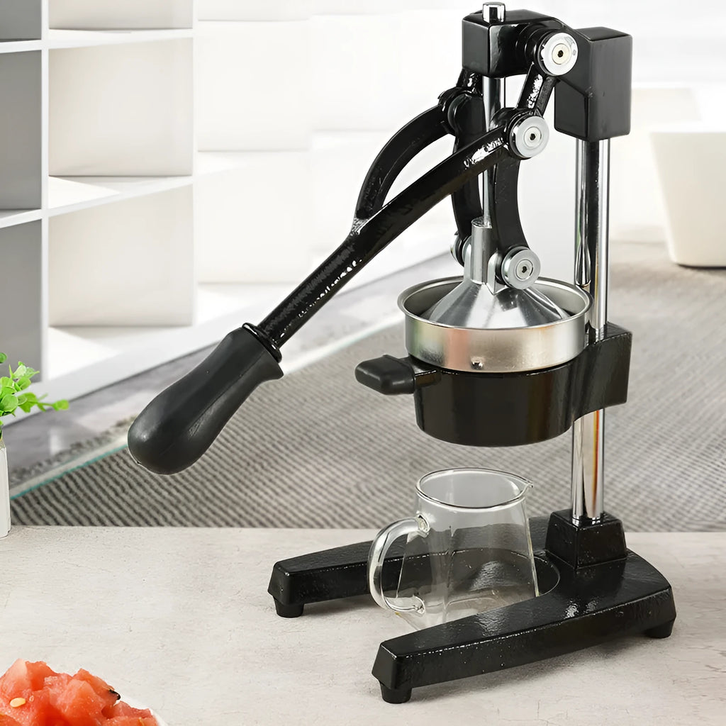 A tall black cast iron manual citrus juicer with a stainless steel strainer on a kitchen counter.