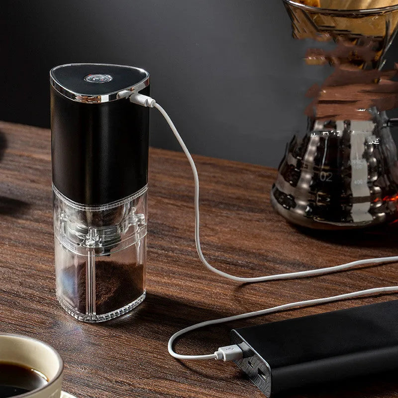 White and black portable electric coffee grinder with ceramic burr and USB charging cable.