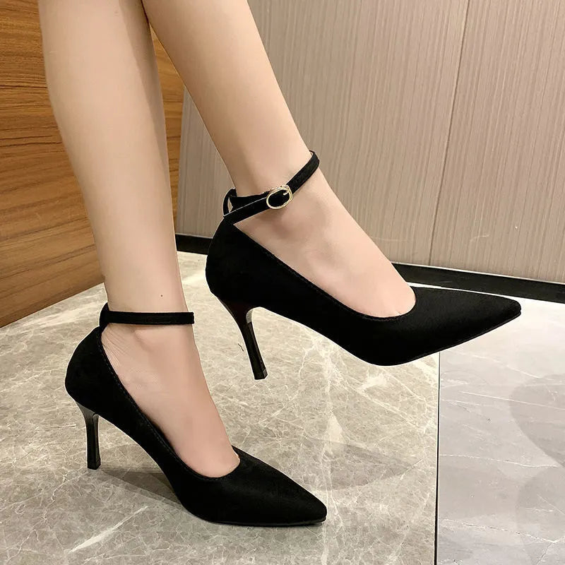 Black women's stiletto heel pumps with a skull pattern and buckle detail on a white background.
