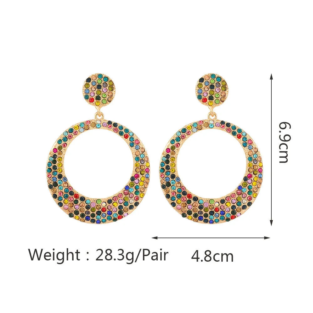 Colourful large pendant earrings with round diamond-shaped studs on a cartoon-style metal setting.