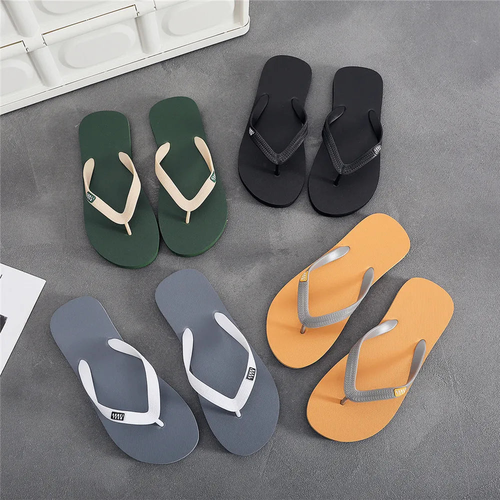 Men's black rubber sole flip-flops with an EVA foam upper on a wooden deck