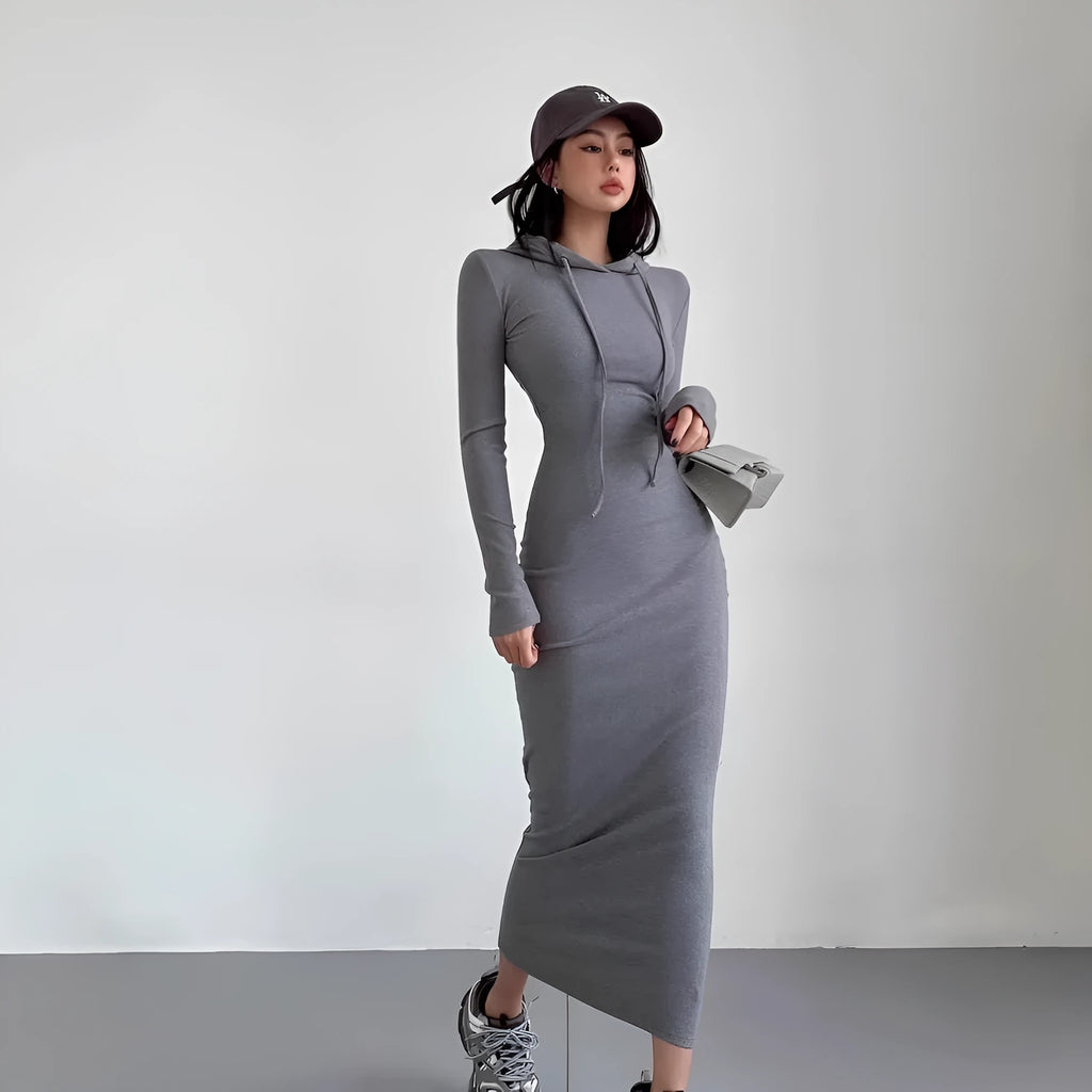 A woman modelling a grey hooded long-sleeve sheath dress with a high waist.