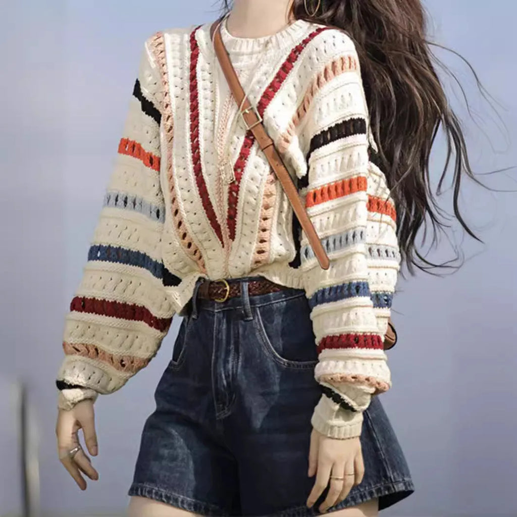 Retro rainbow striped loose fit sweater with batwing sleeves on a hanger.