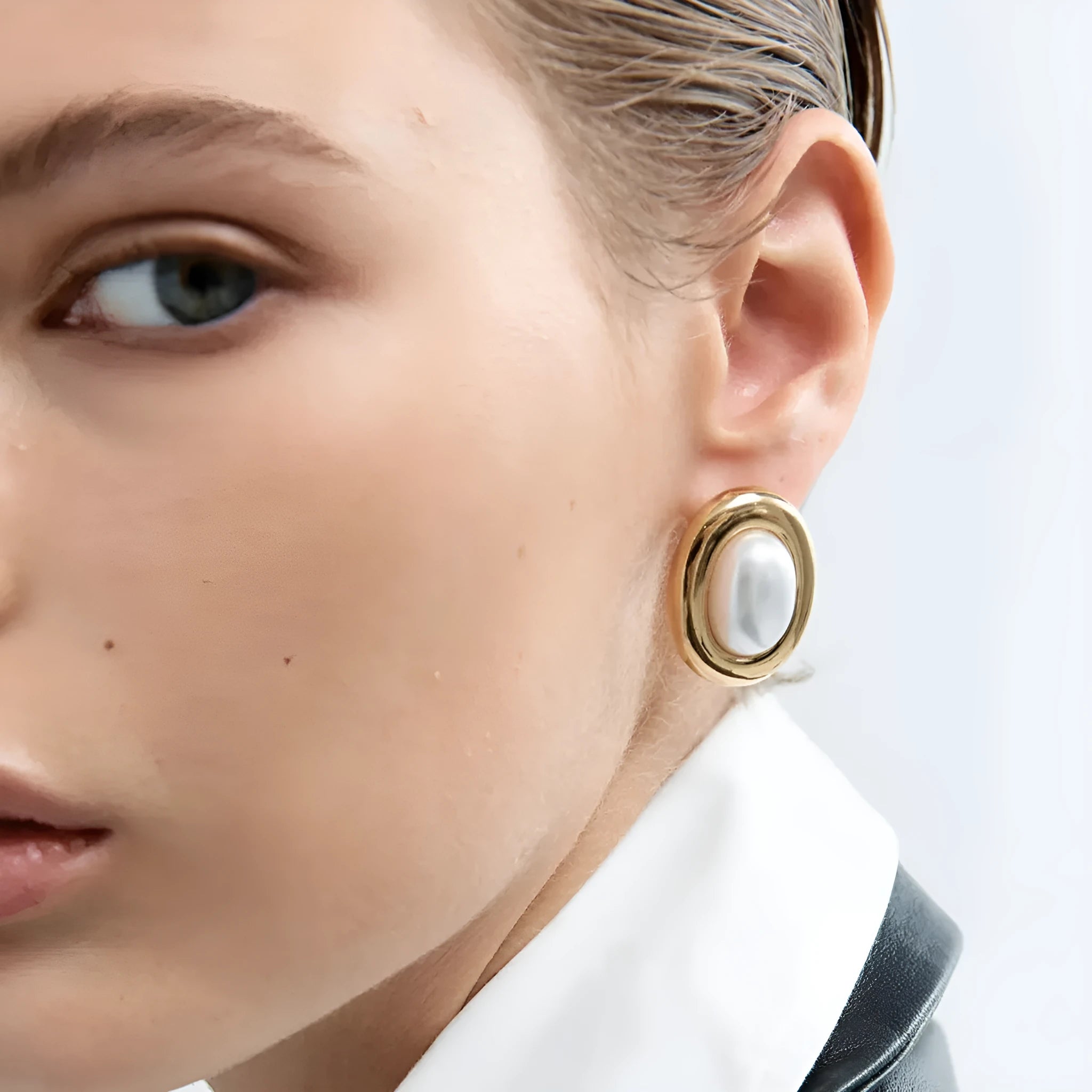 A pair of stainless steel vintage pearl stud earrings for women with a silver-toned finish and a fixed white pearl.