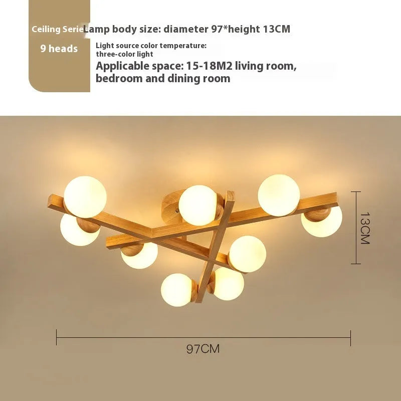 Modern black and copper three-headed pendant ceiling light with adjustable arms hanging over a wooden table