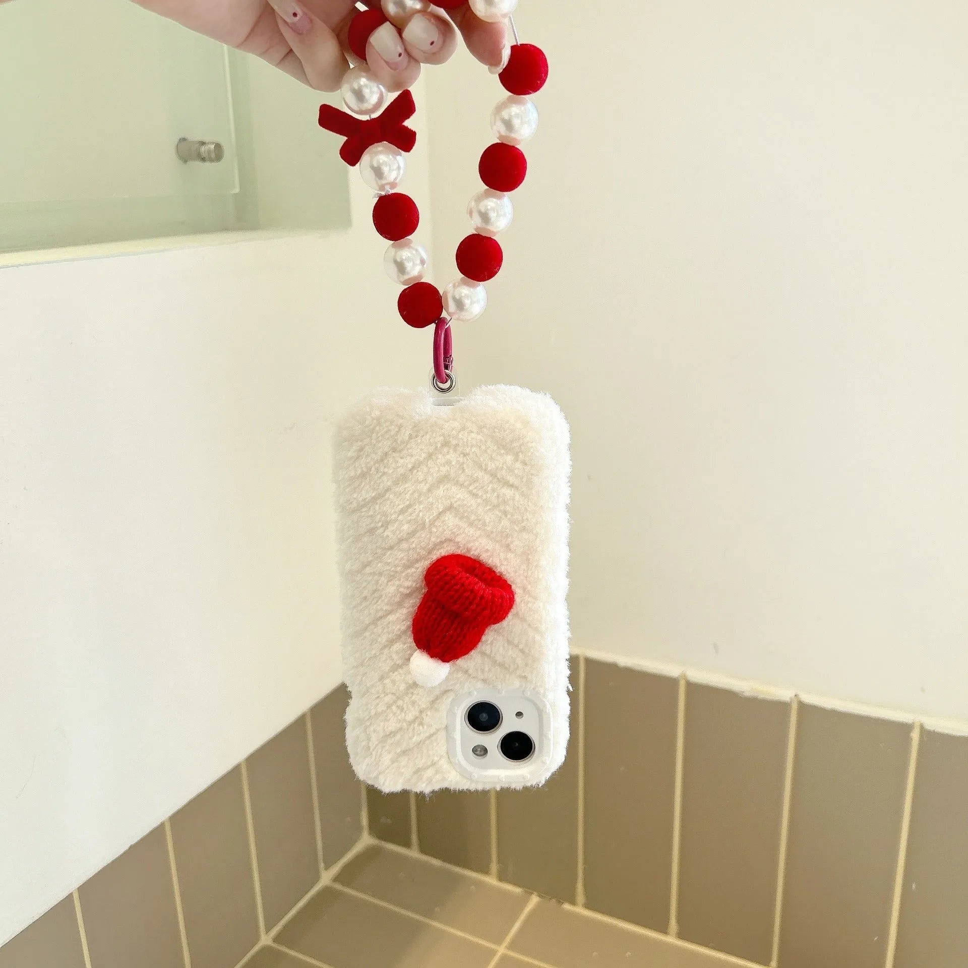 Red silicone phone case with plush Christmas hat bracelet for iPhone 14 Pro Max, back view