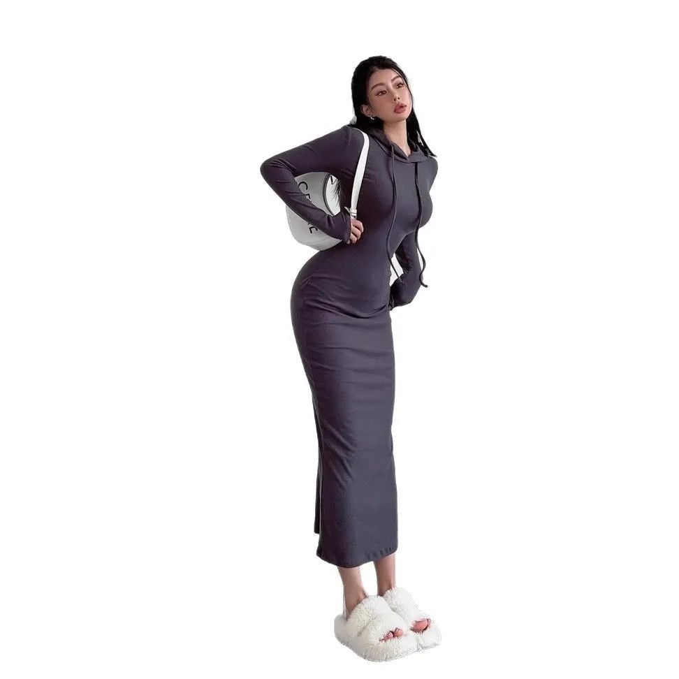 A woman modelling a grey hooded long-sleeve sheath dress with a high waist.