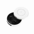 Black wireless semi-in-ear headphones nestled inside a compact white charging case with lid open.