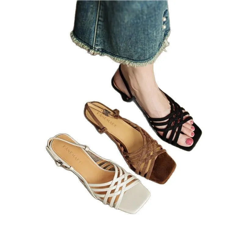 Women's light brown retro sandals with thin cross straps, square toe, and a mid-height block heel on a wooden floor.