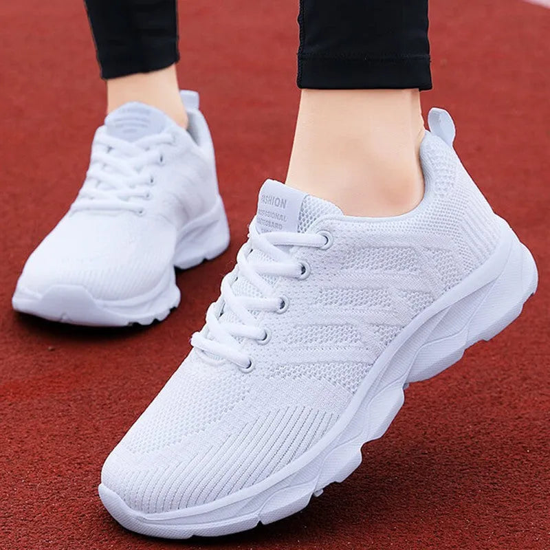 Women's white mesh leisure shoes with lace-up closure and low heel on neutral background