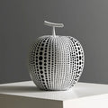 A tall black resin vase and a low white resin apple decoration on a wooden table.