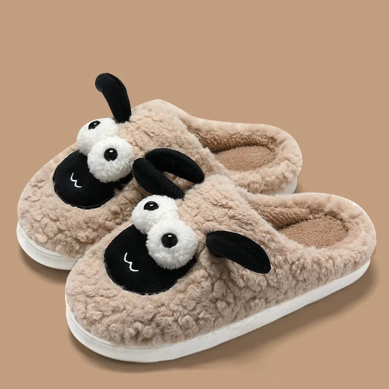 Brown suede slip-on slippers with a light-coloured PVC sole on a wooden floor.