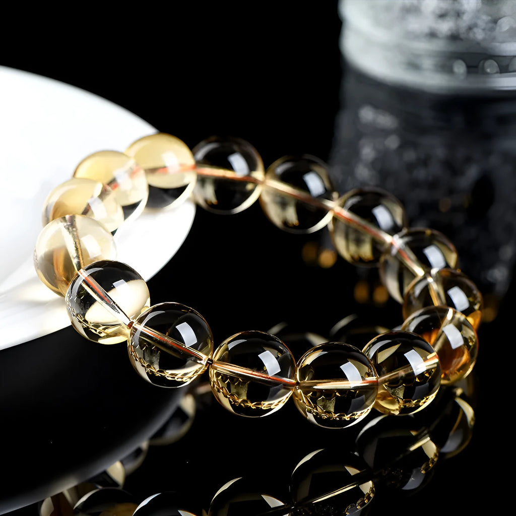 Natural yellow citrine scattered beads bracelet on a wrist, showing polished gemstones on a knotted cord.