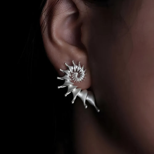A pair of alloy conch-coloured stud earrings with an irregular three-dimensional shape and a matte finish.