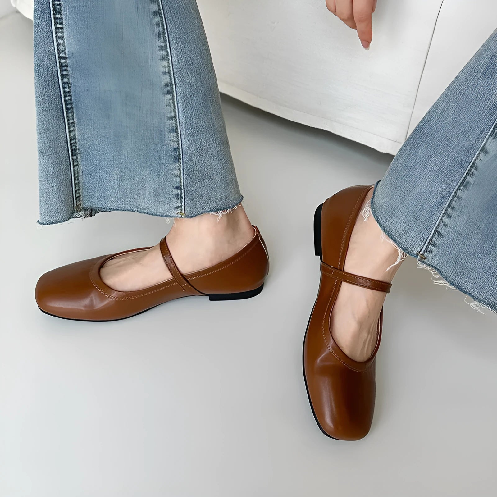 Women's black sheepskin Mary Jane flat shoes with round toe and flat rubber sole on a white background.