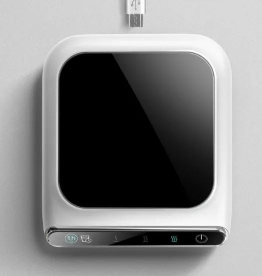 Black USB cup warmer with temperature controls and reminder light on desk