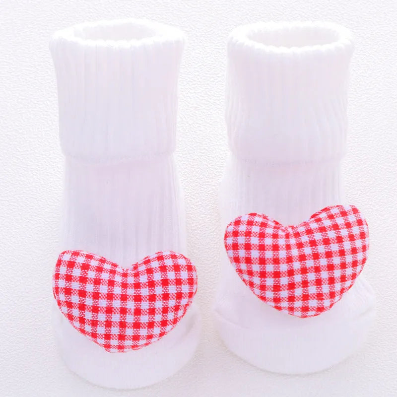 Cotton baby floor socks in assorted colours and prints like blue bow and pink stars on a size chart.