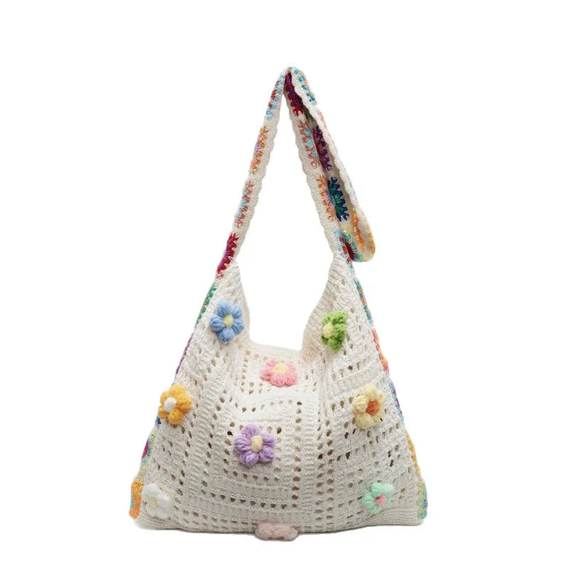 Women's casual white woven hollow beach bag with single shoulder strap on a sandy beach.
