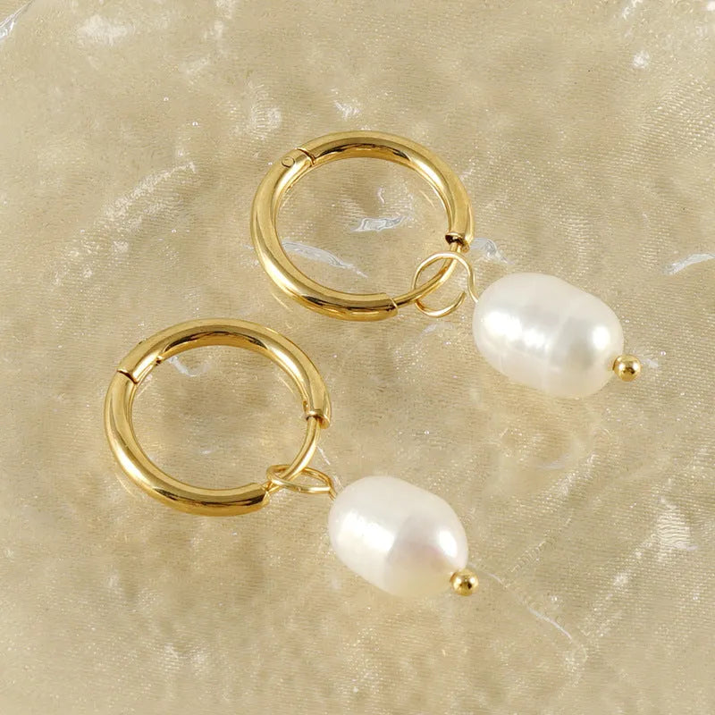 A pair of gold geometric drop earrings featuring stainless steel construction and central freshwater pearls.
