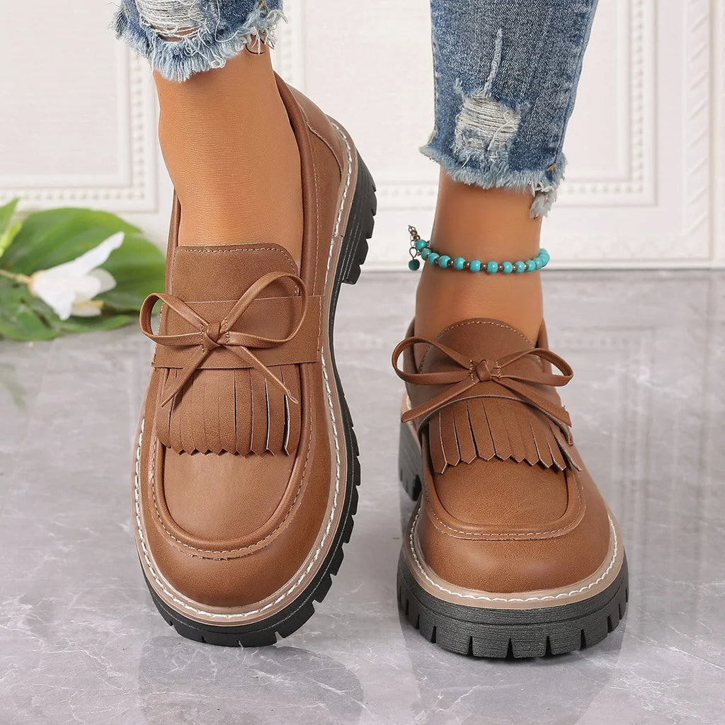 Black plus size women's loafers with a tassel and bowknot on the flat chunky heel.