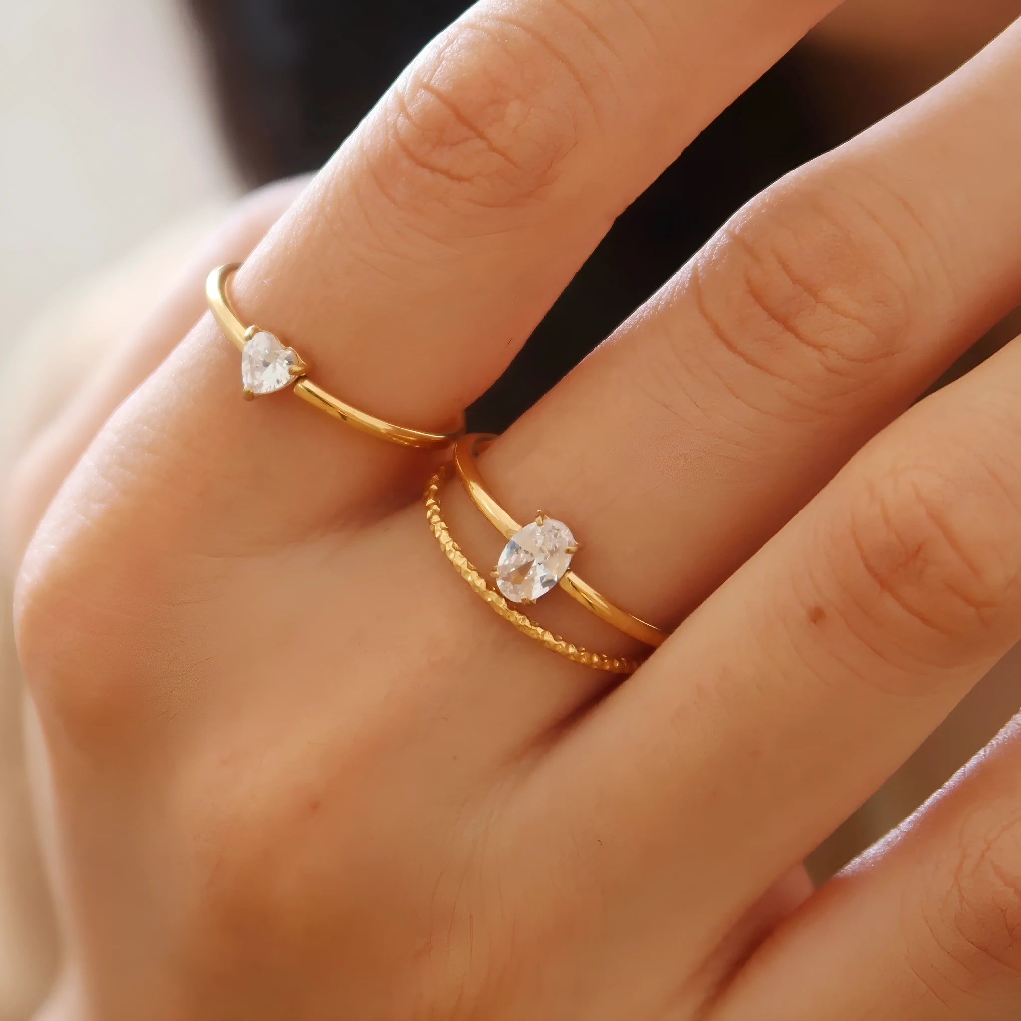 Golden heart-shaped stainless steel ring with electroplated finish shown in UK sizes 5-8