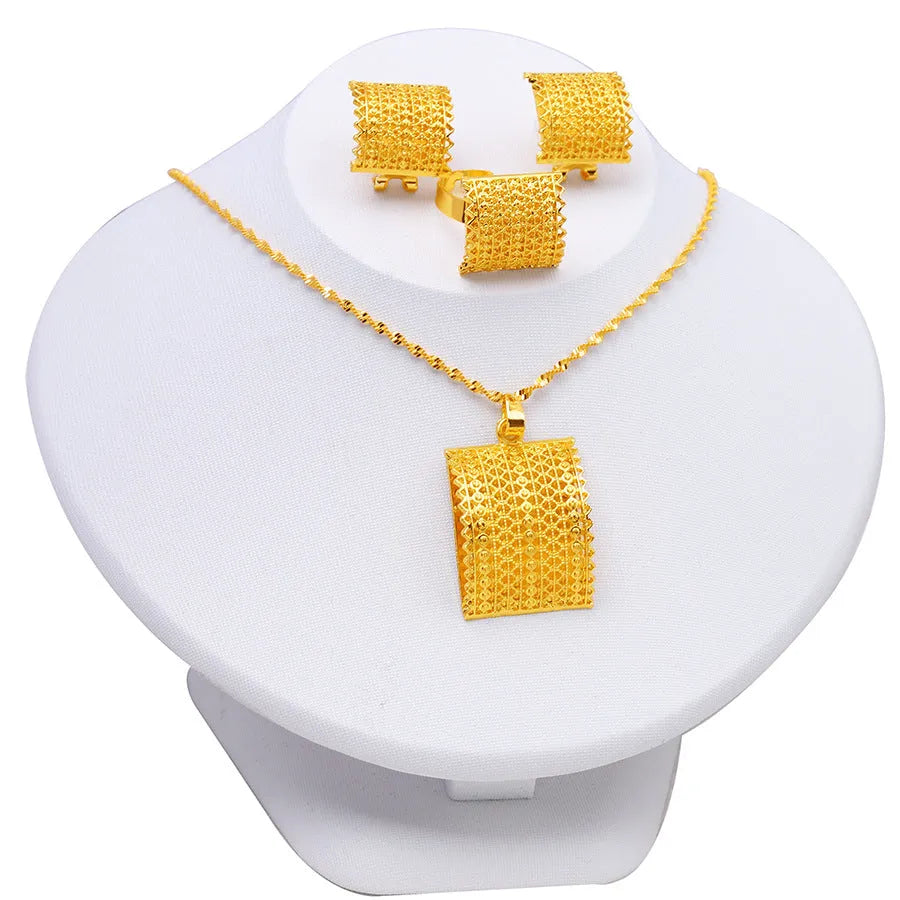 Golden bridal jewellery set comprising a copper necklace, earrings, and ring on a display.