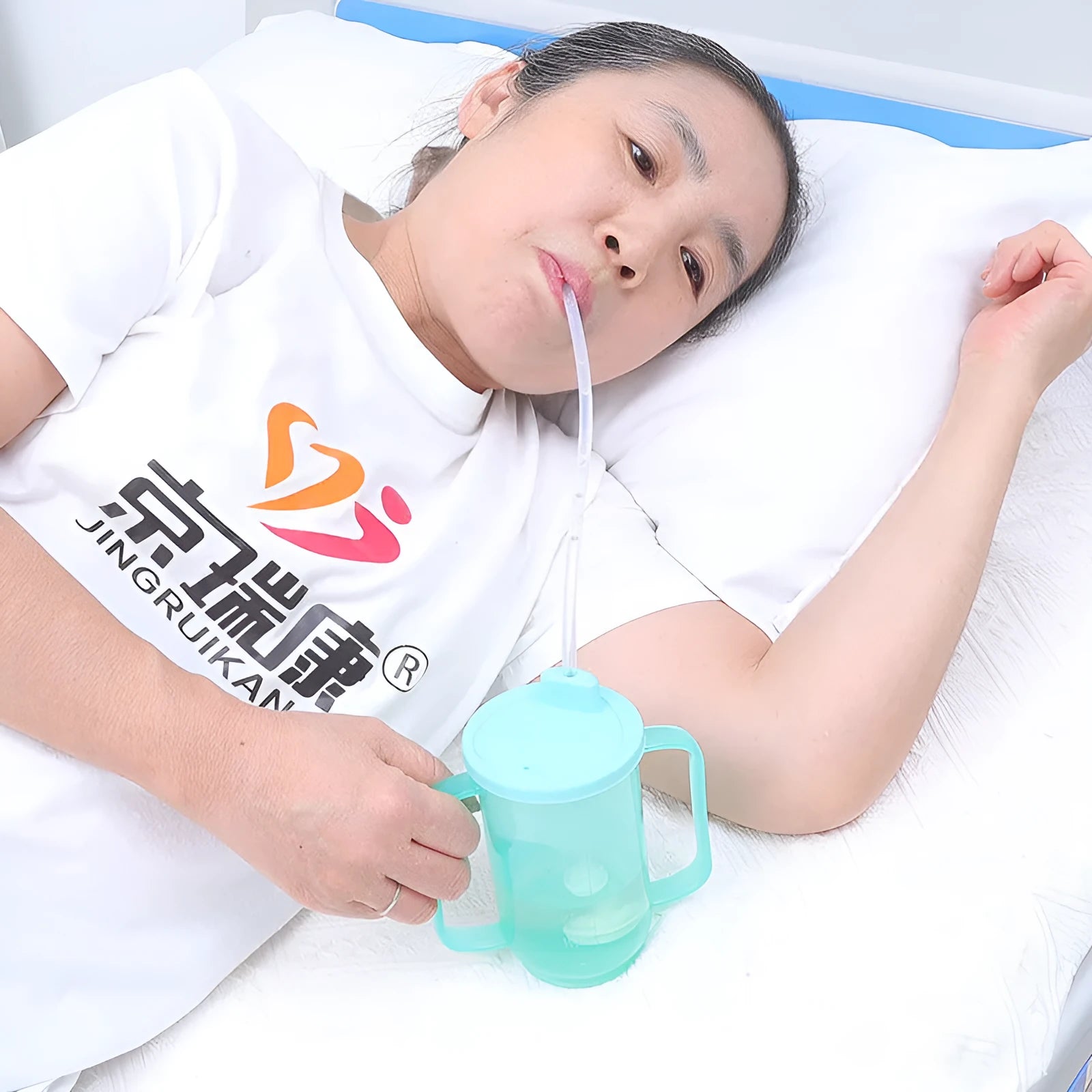 Adult polypropylene drinking cup with oblique choke-proof spout, lid, handle, and optional wrist splint.