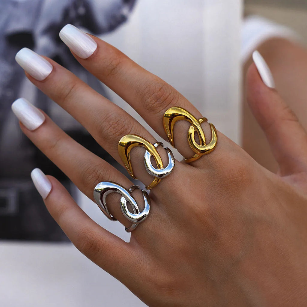 Geometric lines hollow out stainless steel ring with PVD gold plating on a neutral background