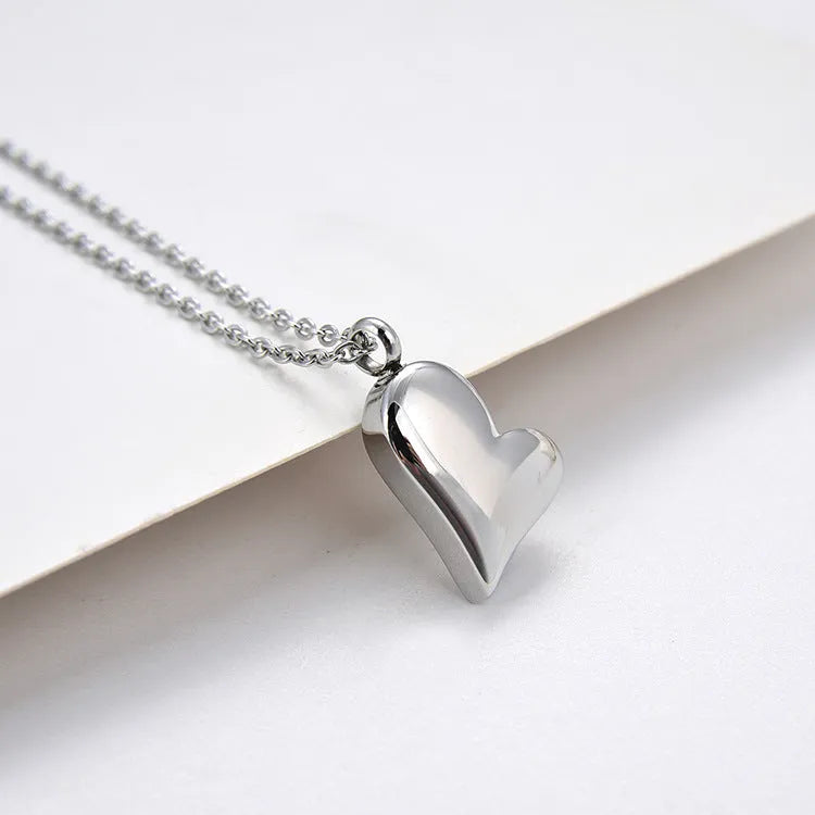 Silver curved peach heart stainless steel pendant necklace on adjustable length chain