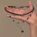 Women's layered leather heart necklace on alloy chain, showing adjustable length and crystal details.