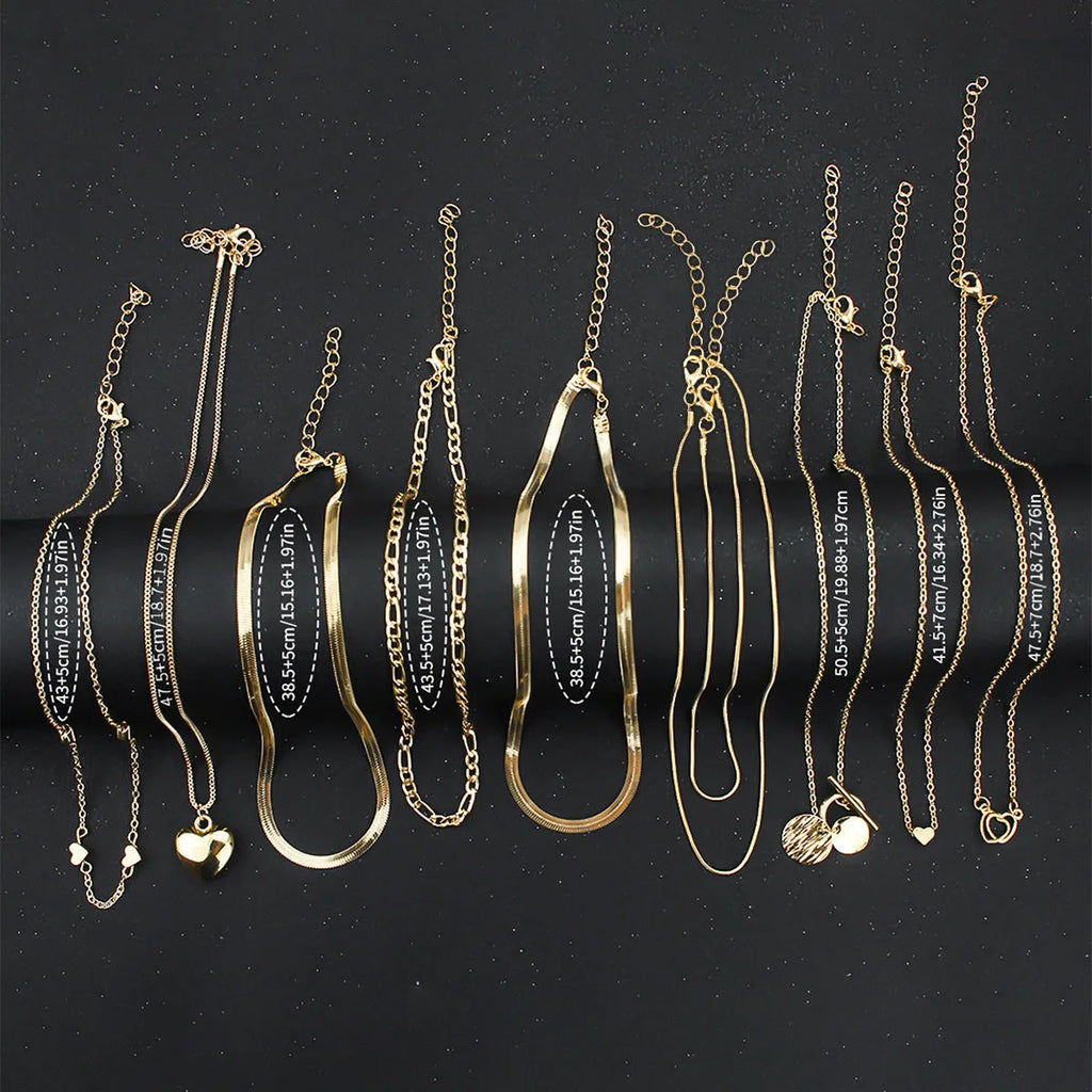 Set of ten gold women's fashion necklaces with snake bone chains and adjustable length on a white background.