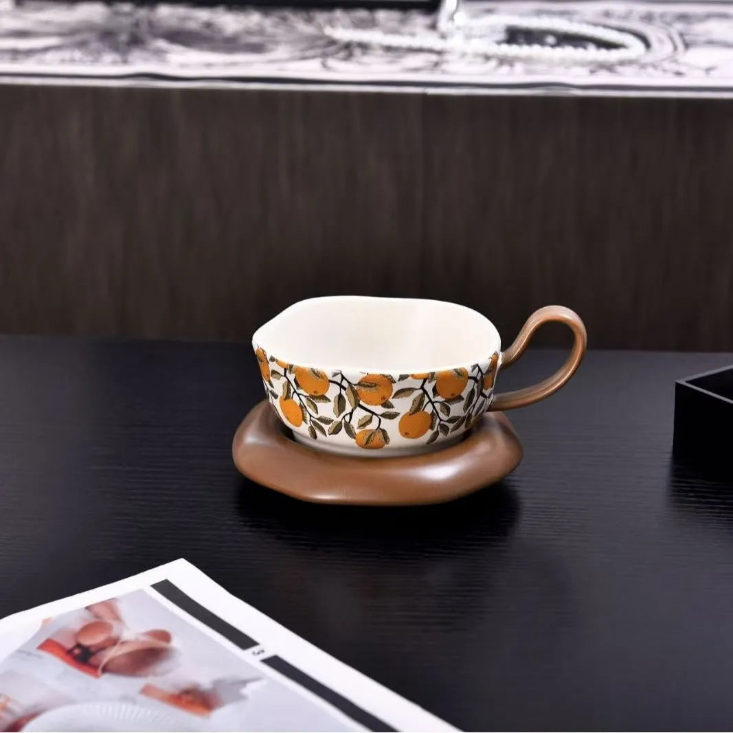 Antique-style ceramic coffee cup and saucer set with a retro pattern in either black or orange.