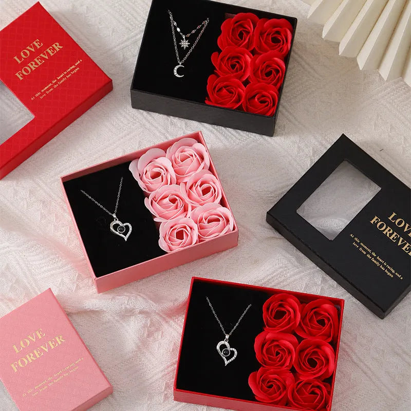 Red Valentine's gift box open to show six pink soap roses with a matching handbag beside it