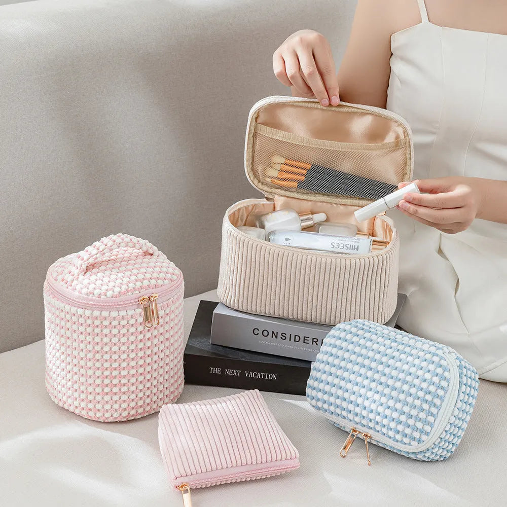 Set of four small pink cube-shaped flannelette makeup bags with zips, arranged together.