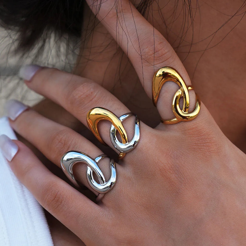 Geometric lines hollow out stainless steel ring with PVD gold plating on a neutral background