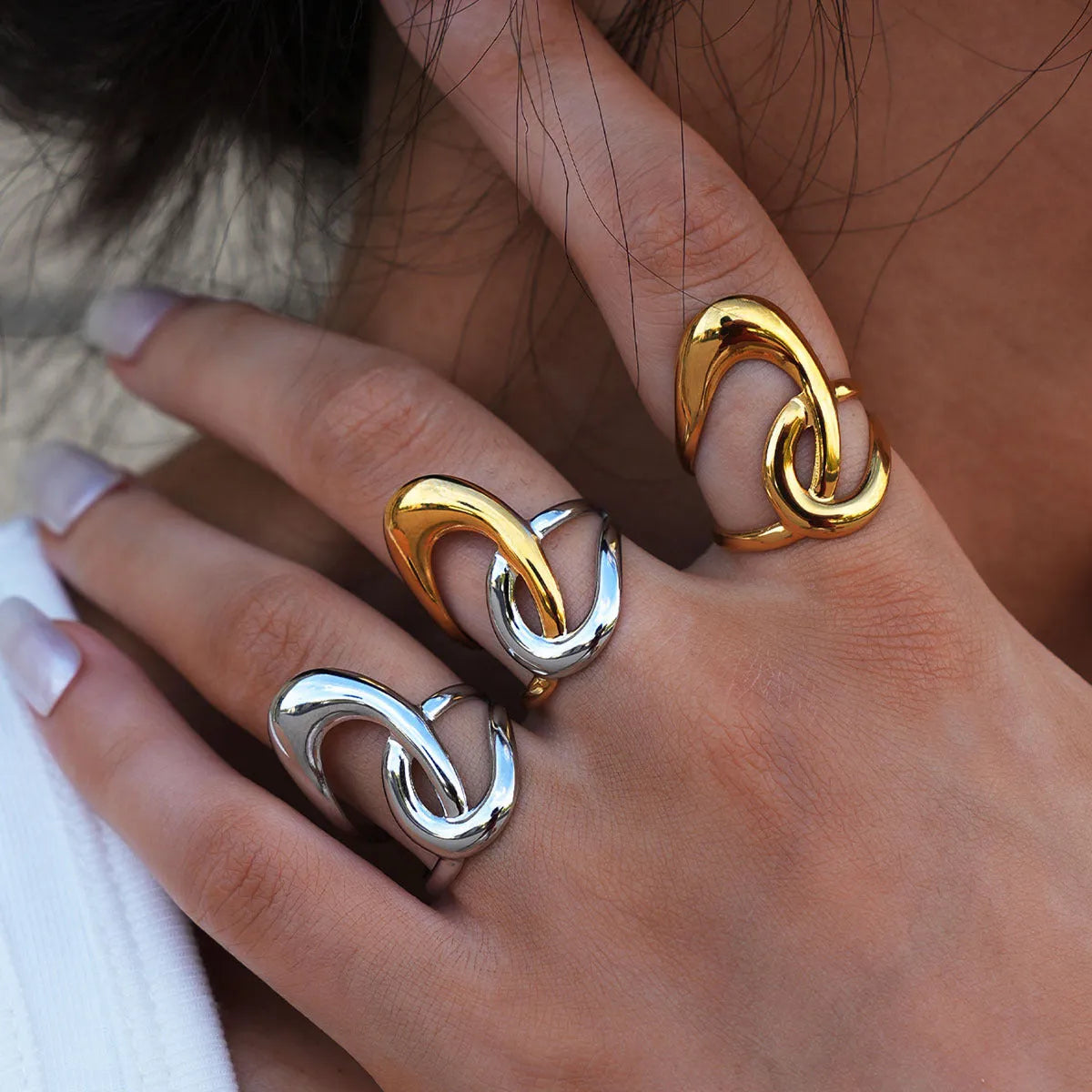 Geometric lines hollow out stainless steel ring with PVD gold plating on a neutral background