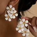 Retro flower-shaped iron earrings for women in black or white with baking varnish finish.