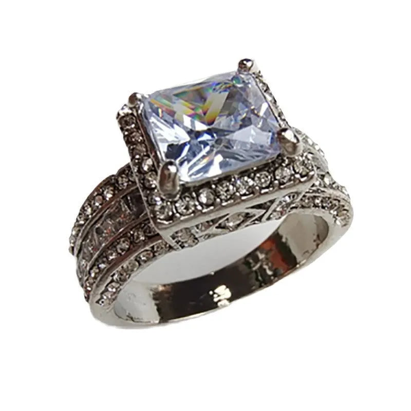 Geometric women's alloy ring with round detail in gold or white electroplated finish on a finger.