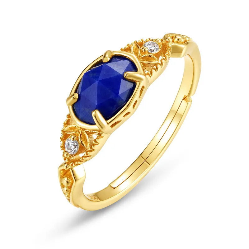A silver geometric ring with a natural blue lapis lazuli stone, showing ellipse shape and round details.