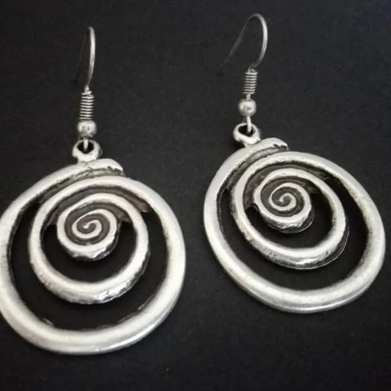 Pair of silver geometric spiral earrings with a distressed finish on a white background.