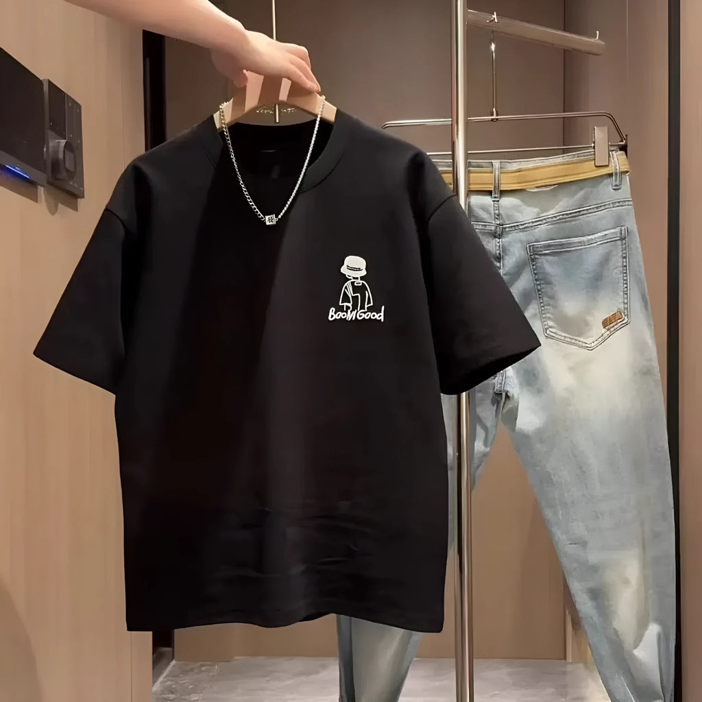 Man wearing a black slim fit pure cotton t-shirt with a simple cartoon print design on the front.