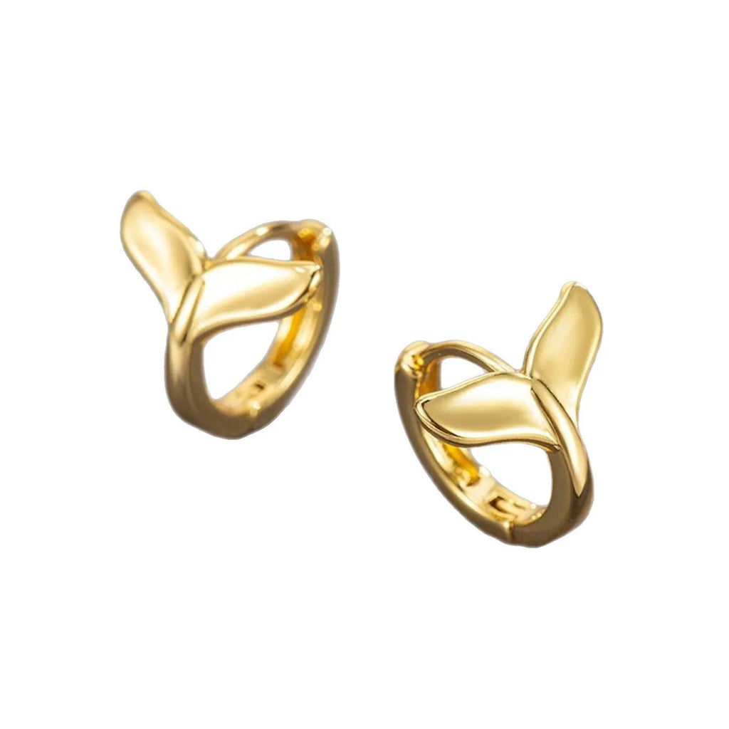 A pair of simple women's fishtail earrings in a gold tone finish on a copper base.