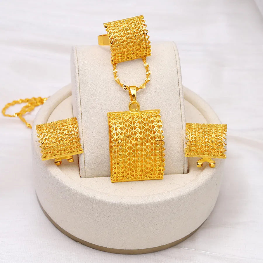 Golden bridal jewellery set comprising a copper necklace, earrings, and ring on a display.